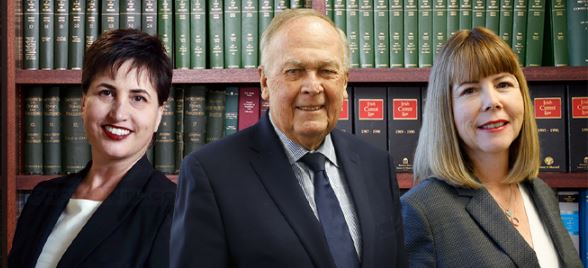 A man in suit and tie standing next to two other people.