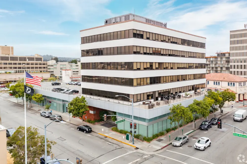 A large building with cars driving down the street.